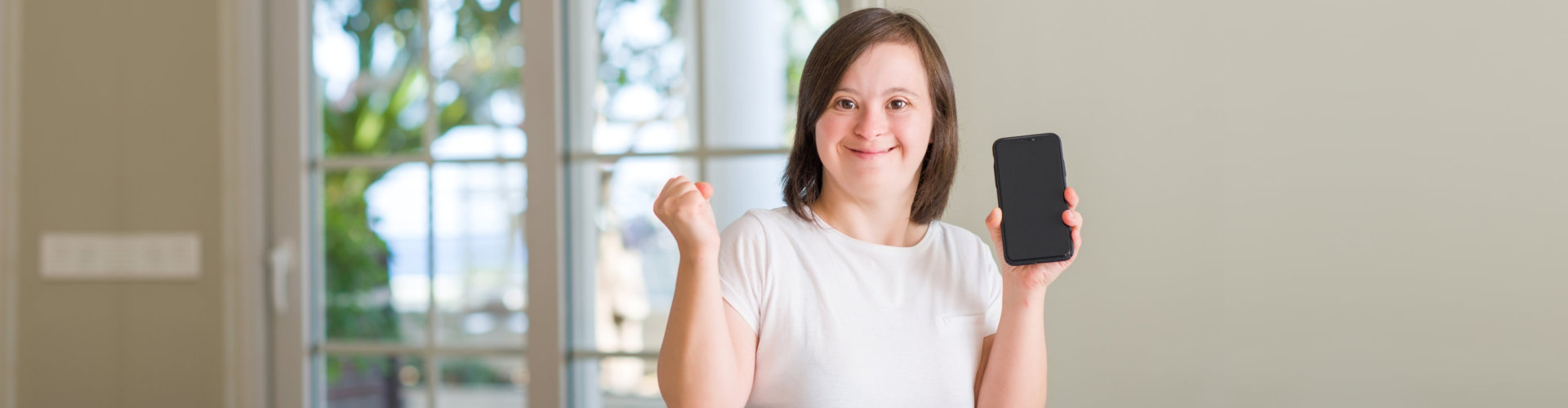 Down syndrome woman at home using smartphone